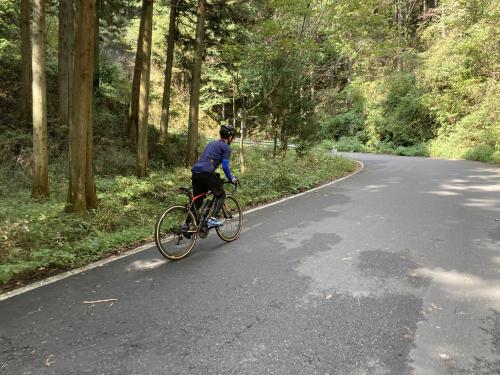 坂道をロードバイクでのぼる男性の写真