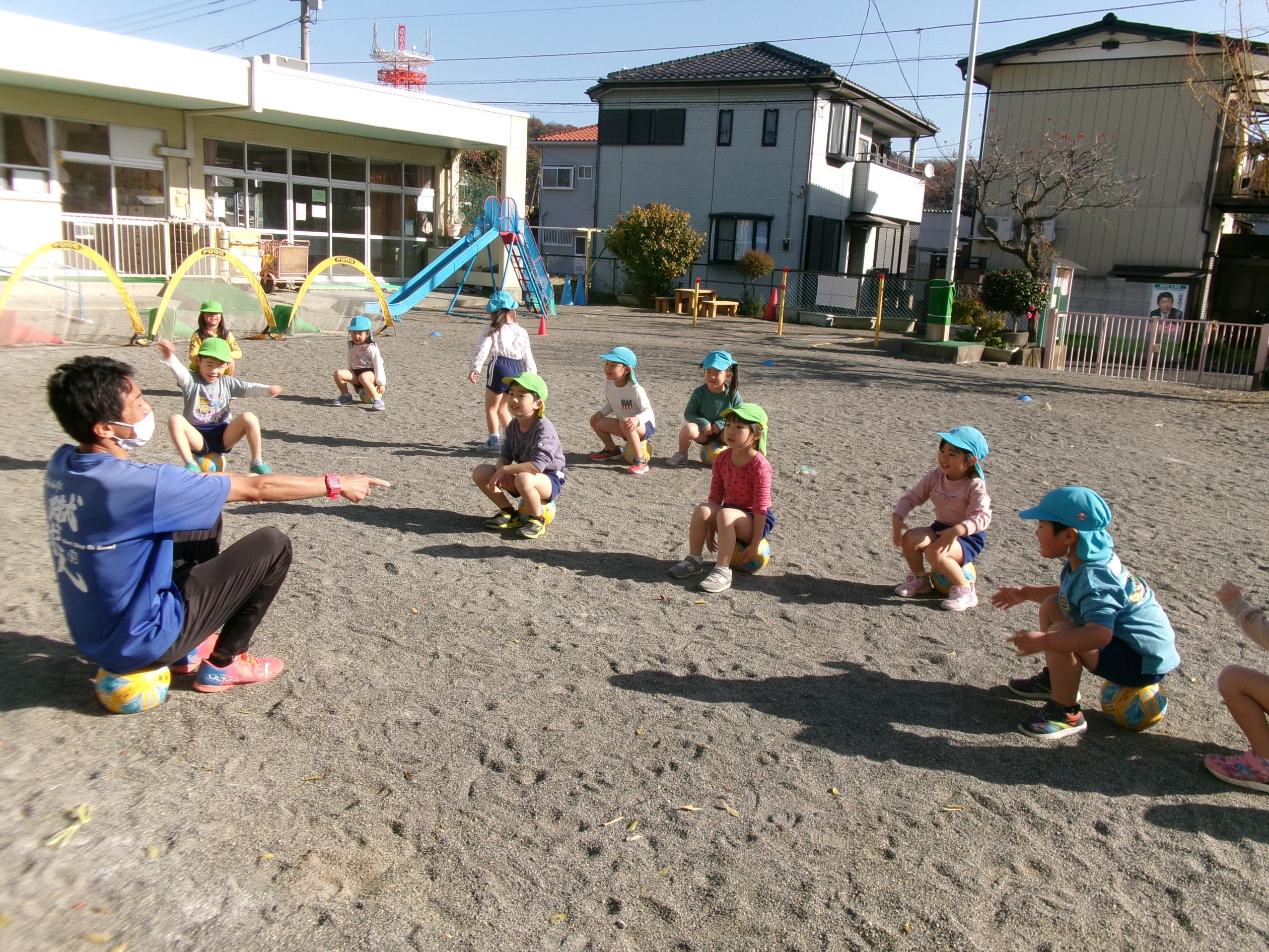 サッカー教室の先生のお話しを聞いている子どもたちの写真です