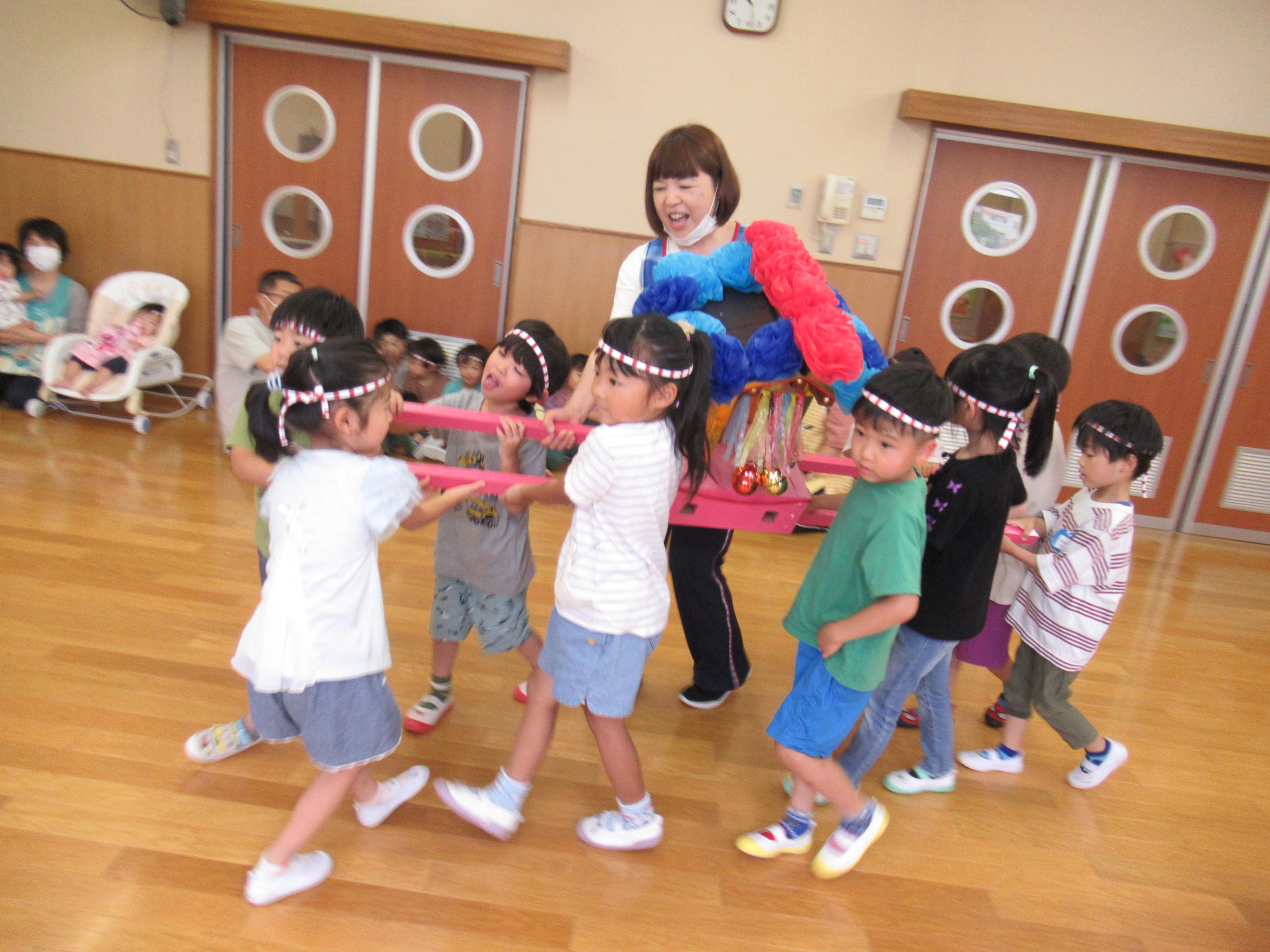 子どもが御神輿を担いでいる写真