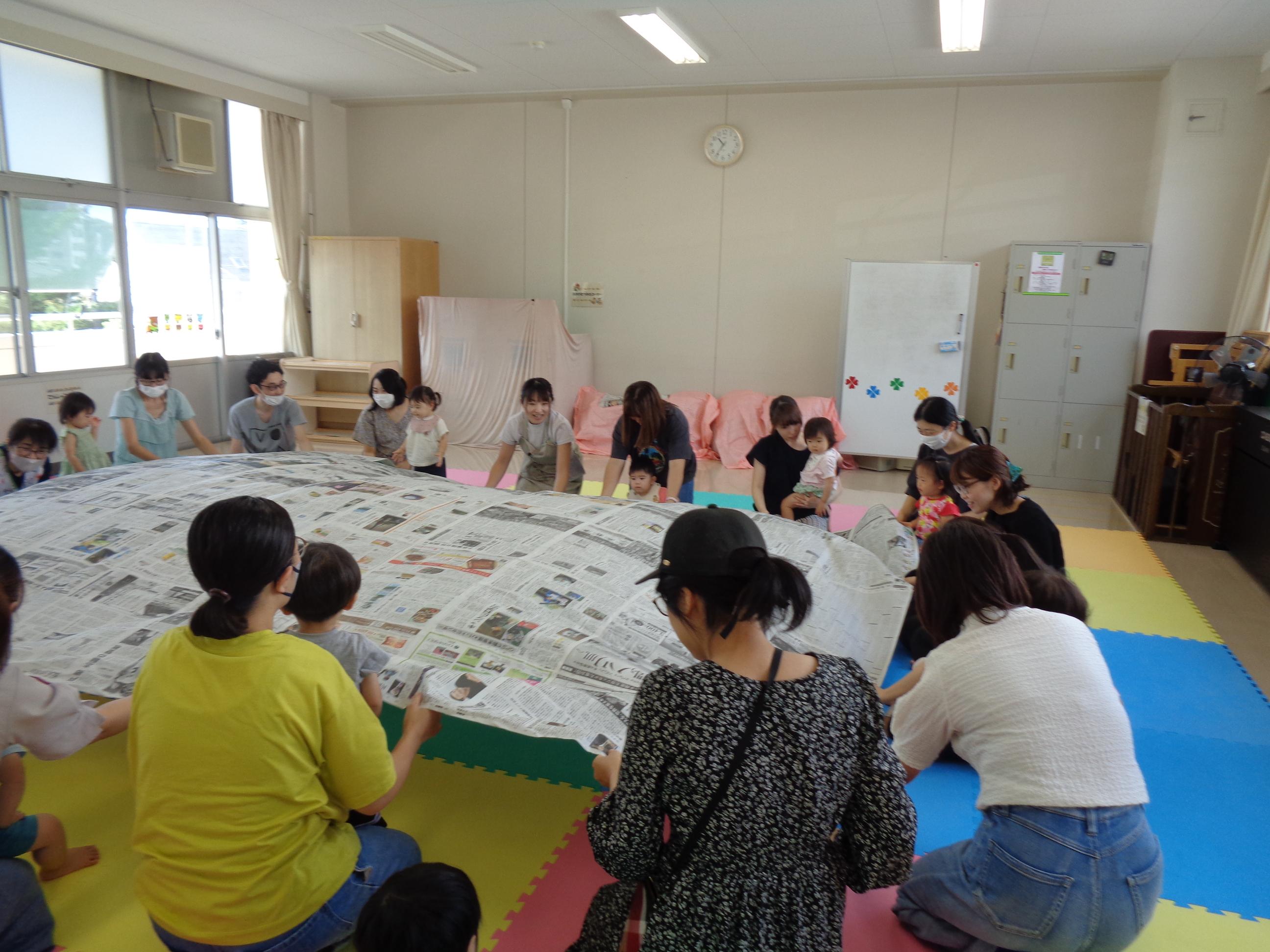 新聞紙で遊んでいる写真です。