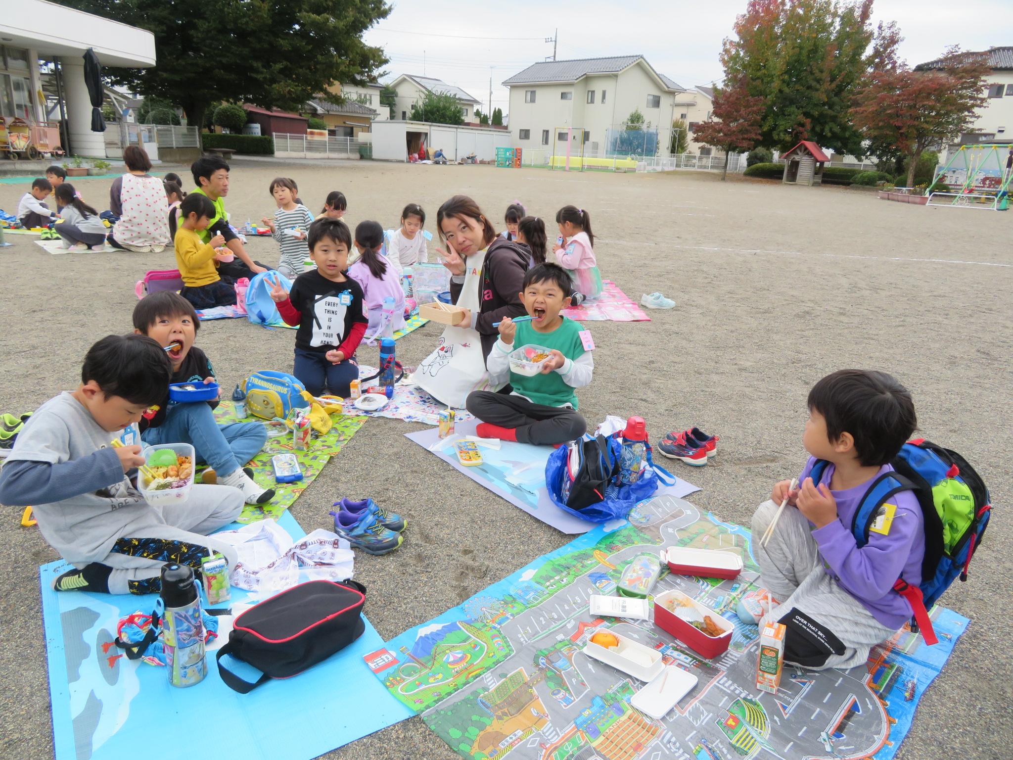 シートを敷いてお弁当を食べている様子