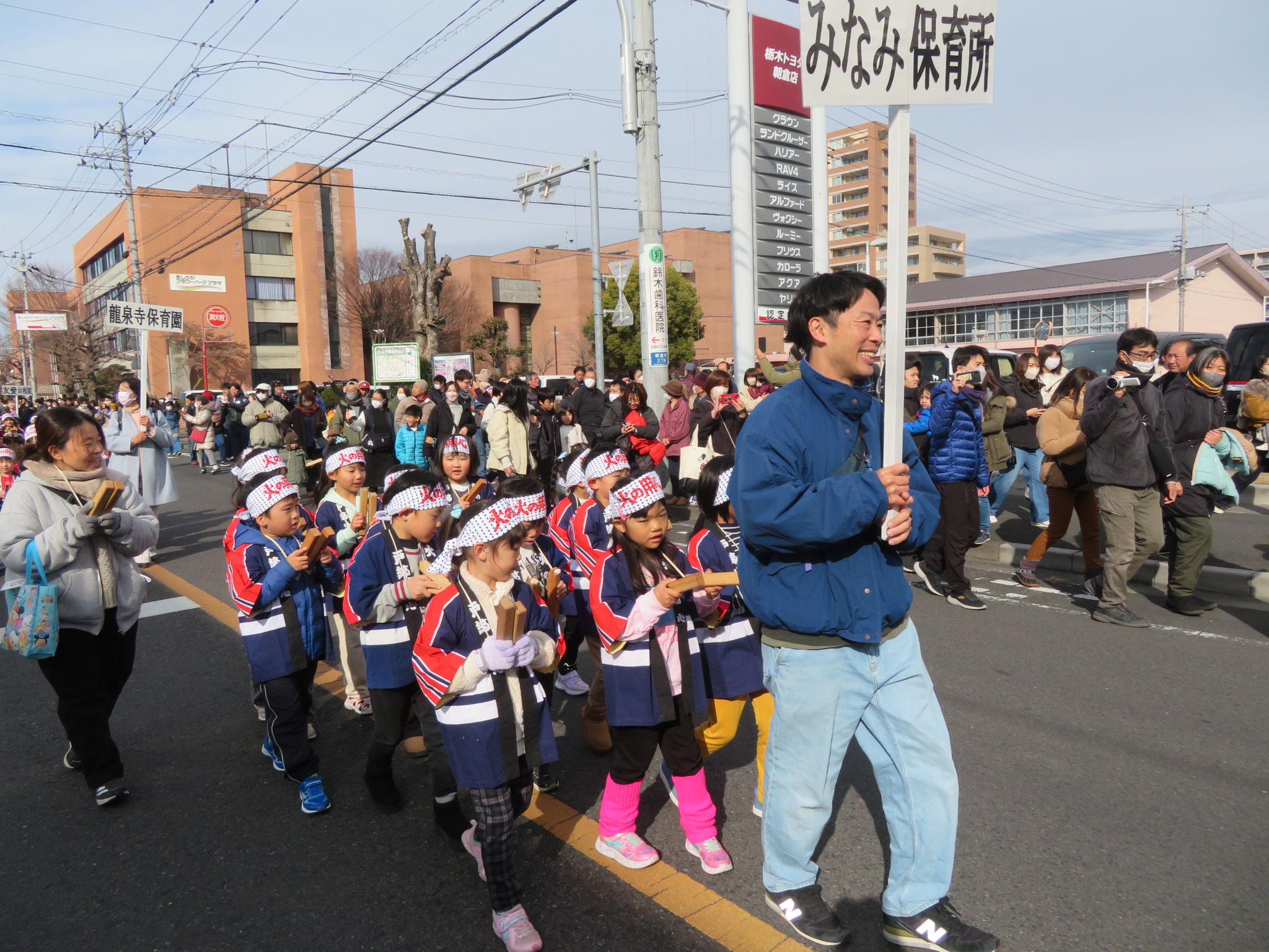 保育士を先頭に子ども達が歩く写真