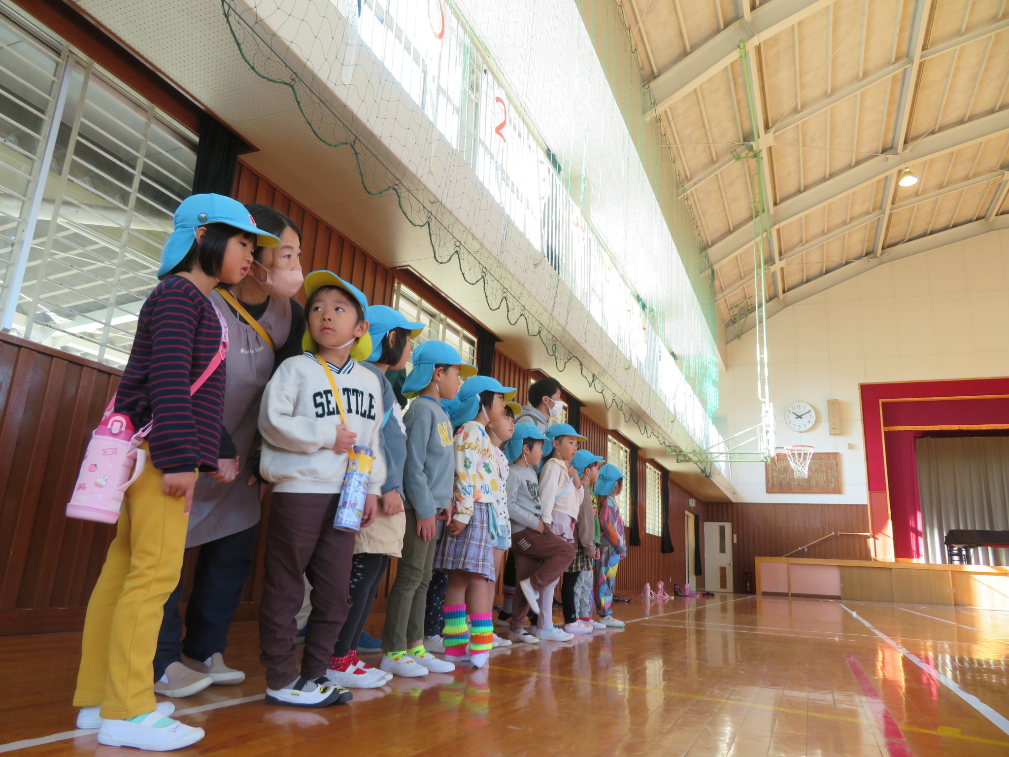 大きな体育館に驚いている子ども達の写真