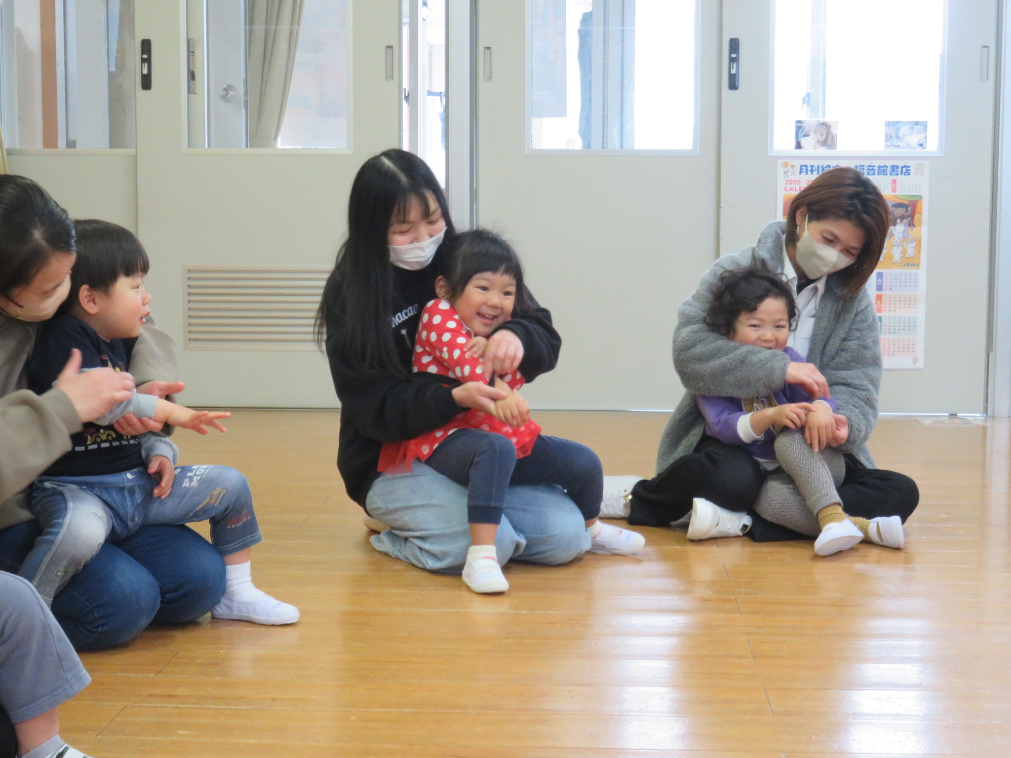 親子でわらべうた遊びを楽しんでいる写真